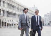Des hommes d'affaires souriants traversent la place Saint-Marc à Venise — Photo de stock