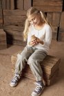 Girl holding chick in barn — Stock Photo