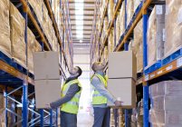 Workers carrying boxes in warehouse — Stock Photo