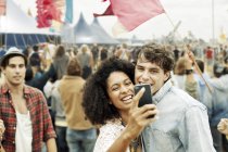 Couple prenant autoportrait avec téléphone caméra au festival de musique — Photo de stock