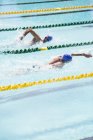 Nadadores correndo na água da piscina — Fotografia de Stock