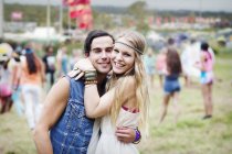 Portrait of couple hugging at music festival — Stock Photo