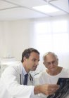 Доктор показ рентгенівські промені до старшого пацієнта в лікарняній палаті — стокове фото