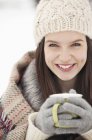 Close up portrait of woman in knit hat and gloves drinking coffee — Stock Photo