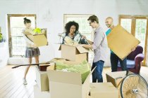 Friends unpacking boxes in new home — Stock Photo