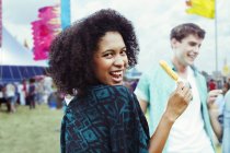 Retrato de la mujer comiendo hielo aromatizado en el festival de música - foto de stock