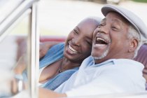 Lächelndes Paar lacht im Auto — Stockfoto