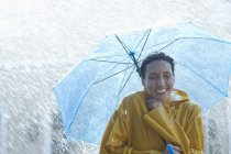 Mujer feliz bajo paraguas bajo la lluvia - foto de stock