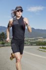 Mujer corriendo por carretera rural - foto de stock