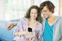 Paar hört gemeinsam auf Sofa Kopfhörer — Stockfoto
