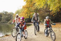 Felice famiglia a cavallo biciclette insieme nel parco — Foto stock