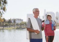 Older couple drinking water after workout — Stock Photo