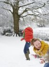 Кавказская счастливая мать и дочь играют в снегу — стоковое фото