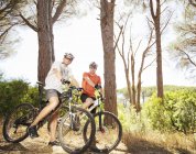 Two adult mountain bikers on dirt path — Stock Photo