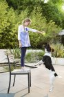 Fille mignonne jouer avec chien en plein air — Photo de stock