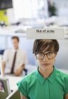 Businesswoman wearing out of order sign at modern office — Stock Photo