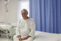 Paciente idoso sentado na cama do hospital — Fotografia de Stock