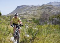 Ciclista de montaña caucásico en camino de tierra - foto de stock