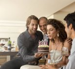Young attractive Woman blowing out birthday candles — Stock Photo
