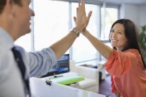 Business people high fiving at modern office — Stock Photo
