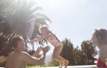 Família feliz brincando na piscina — Fotografia de Stock