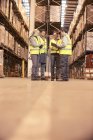 Рабочие разговаривают на складе — стоковое фото