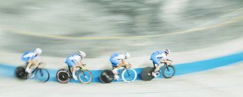 Track cycling team racing in velodrome — Stock Photo