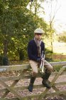 Teenager hält Trompete an Holzzaun — Stockfoto