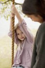 Portrait of girl on swing with mother — Stock Photo