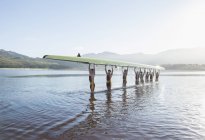 Команда гребцов, держащая навес в озере — стоковое фото