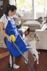 Maid playing with dog in living room — Stock Photo