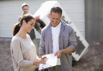 Woman signing for delivery in driveway — Stock Photo