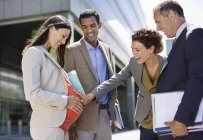 Business people admiring pregnant colleague?s belly — Stock Photo