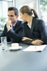 Empresário e empresária conversando em reunião no escritório moderno — Fotografia de Stock