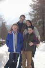 Retrato de família sorridente em pista nevada — Fotografia de Stock