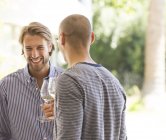 Молоді привабливі чоловіки п'ють вино разом — стокове фото