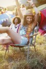 Mulher entusiasmada em cadeira de gramado fora de tendas no festival de música — Fotografia de Stock