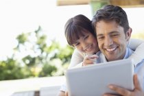 Батько і дочка використовують планшетний комп'ютер разом — стокове фото