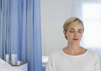 Пацієнт сидить на ліжку в лікарняній кімнаті — стокове фото
