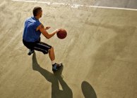 Мужчина играет в баскетбол на площадке — стоковое фото