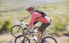 Blurred view of mountain bikers on dirt path — Stock Photo