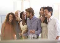 Giovani amici attraenti ridendo insieme alla festa — Foto stock