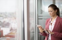 Mujer de negocios usando tableta digital en la oficina moderna - foto de stock