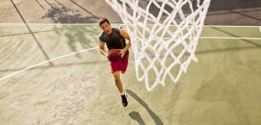 Високий кут зору чоловіка, який грає в баскетбол на дворі — стокове фото