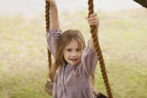 Portrait of happy smiling girl on swing — Stock Photo