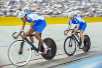 Track cyclists in velodrome — Stock Photo