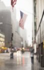 Blurred view of American flags on city street — Stock Photo