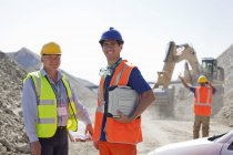 Worker and businessman standing in quarry — Stock Photo
