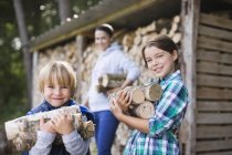 Kinder tragen Brennholz ins Freie — Stockfoto