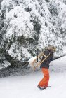 Мальчик с деревянными санями в снегу — стоковое фото